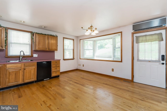 kitchen with a wealth of natural light, dishwasher, sink, and light wood-type flooring