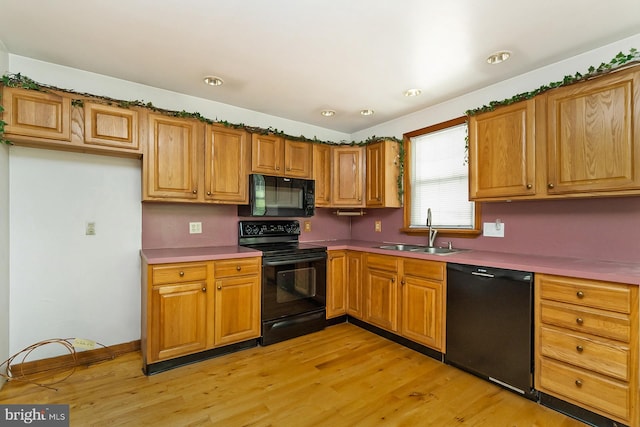 kitchen with black appliances, light hardwood / wood-style floors, and sink