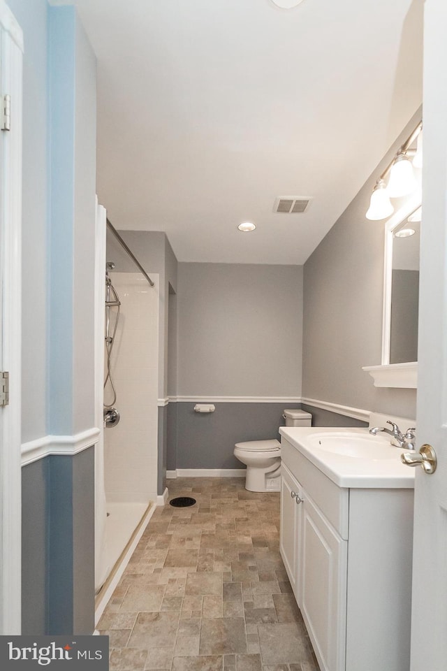 bathroom with vanity, toilet, and walk in shower