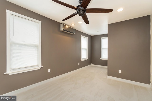 spare room with ceiling fan, light colored carpet, and a wall mounted air conditioner