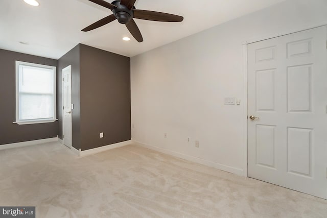 carpeted empty room featuring ceiling fan