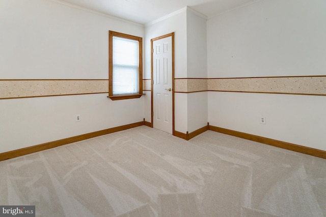 spare room with crown molding and light colored carpet