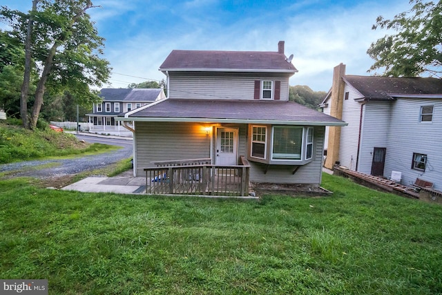 back of house featuring a yard and covered porch