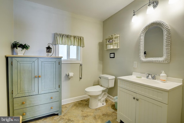 bathroom featuring tile patterned flooring, toilet, and vanity