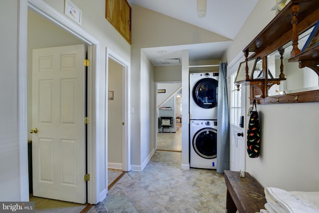 washroom with stacked washing maching and dryer and light tile patterned floors