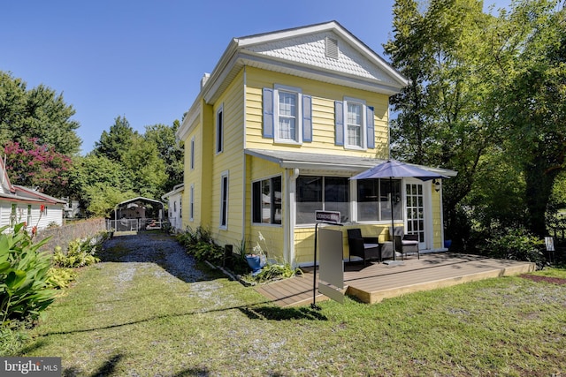 back of house featuring a wooden deck and a yard