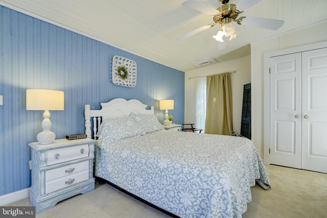 carpeted bedroom with ceiling fan and a closet