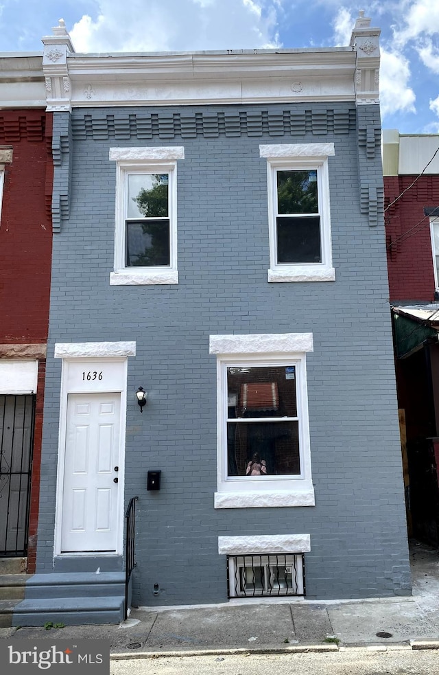 view of front of home with entry steps and brick siding