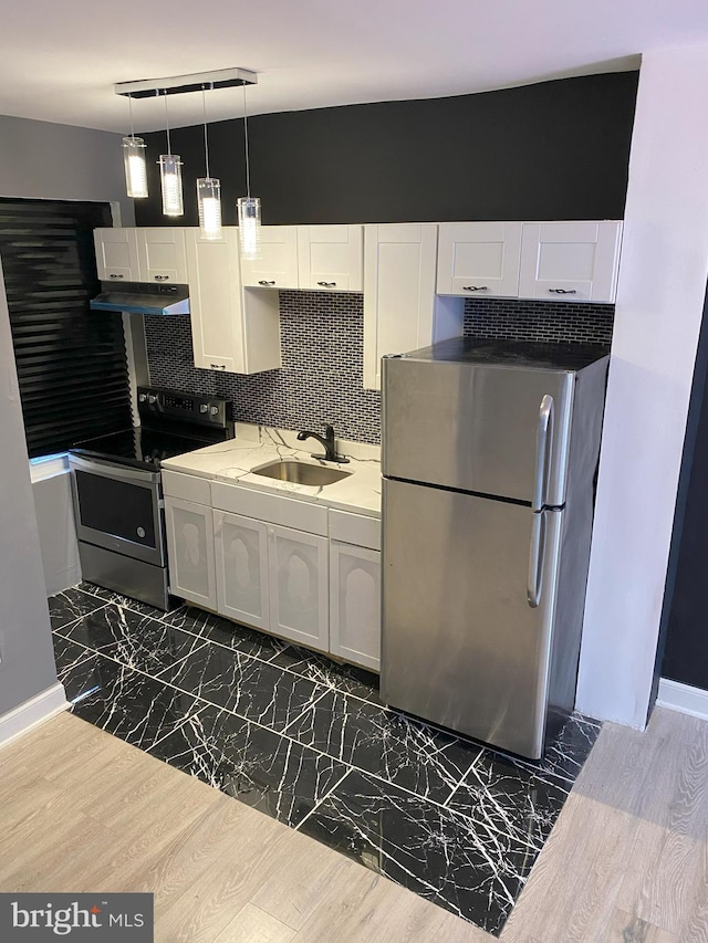 kitchen featuring backsplash, dark wood-type flooring, appliances with stainless steel finishes, rail lighting, and decorative light fixtures