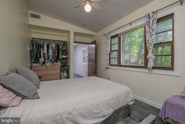 bedroom featuring ceiling fan, dark hardwood / wood-style floors, vaulted ceiling, and a closet