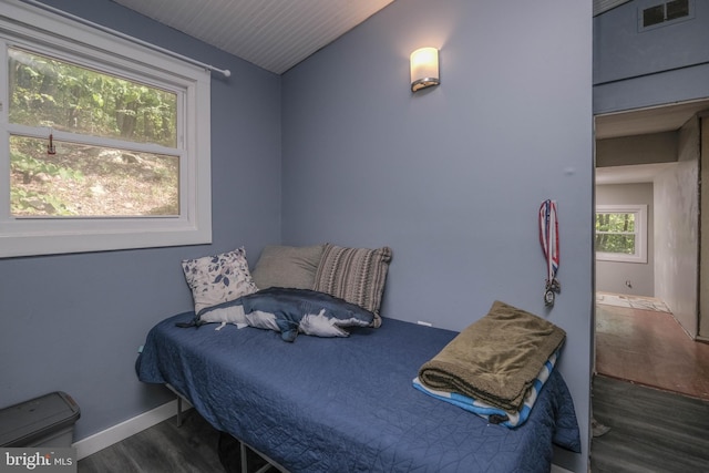 bedroom with dark hardwood / wood-style flooring and vaulted ceiling