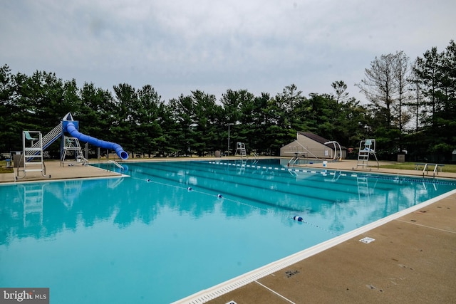 view of pool featuring a water slide and a playground