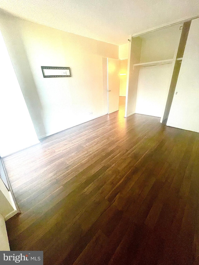 unfurnished room with dark hardwood / wood-style floors and a textured ceiling