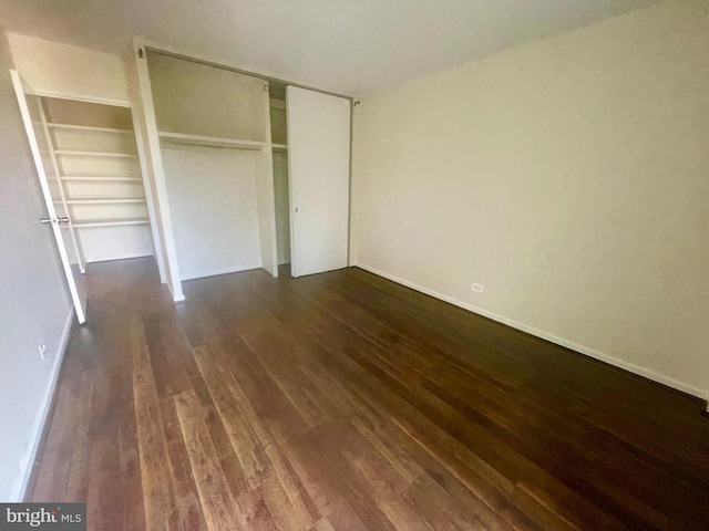 unfurnished bedroom featuring a closet and dark hardwood / wood-style floors