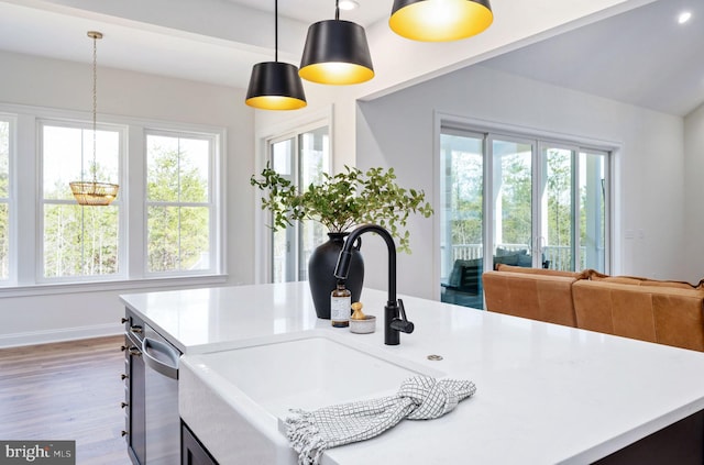 kitchen with sink, hardwood / wood-style floors, hanging light fixtures, and a wealth of natural light