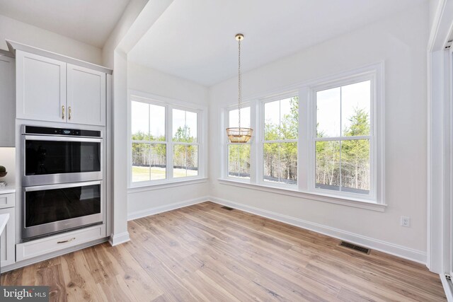 kitchen featuring light hardwood / wood-style flooring, white cabinetry, and stainless steel double oven