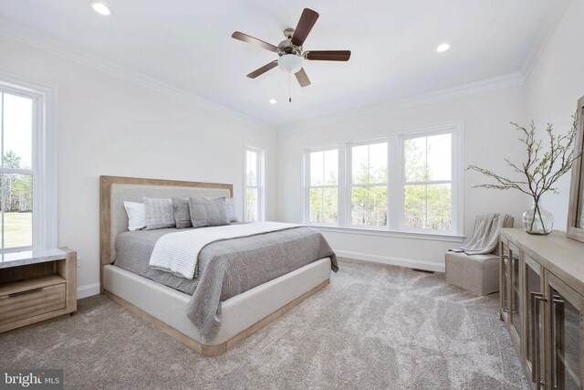 carpeted bedroom with ceiling fan and ornamental molding