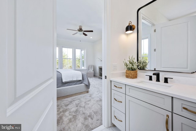 bathroom featuring ceiling fan, crown molding, and vanity