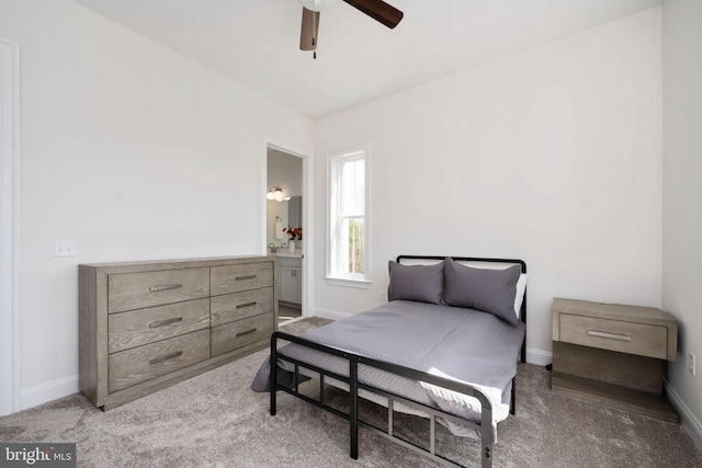 bedroom featuring ensuite bathroom, light colored carpet, and ceiling fan