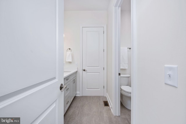 bathroom with vanity, wood-type flooring, and toilet