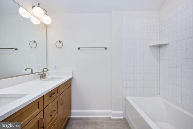 bathroom featuring tile patterned floors, tiled shower / bath, and dual bowl vanity