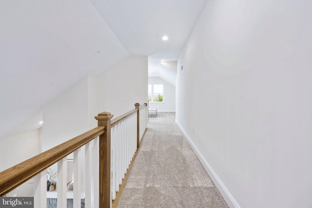 hallway with lofted ceiling and light carpet