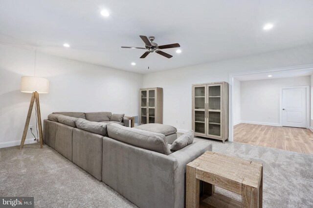 carpeted living room with ceiling fan