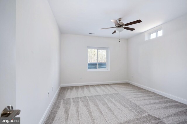 spare room with ceiling fan and light carpet