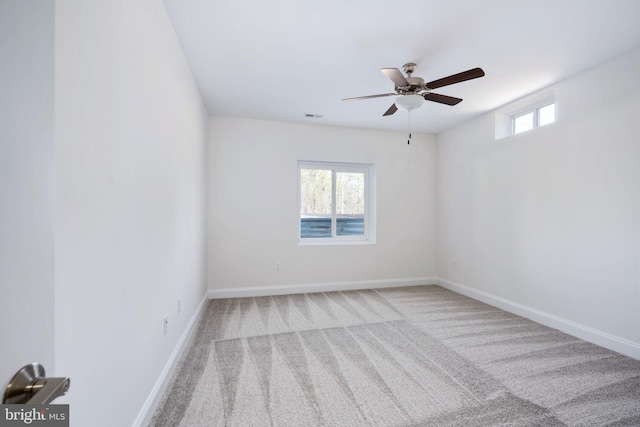 empty room with a healthy amount of sunlight, light colored carpet, and ceiling fan