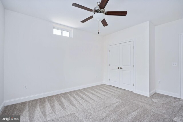 carpeted empty room featuring ceiling fan