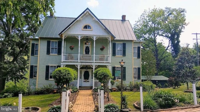 victorian home with a front lawn