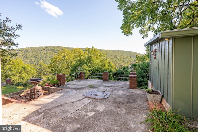 view of patio / terrace with a mountain view and a view of trees