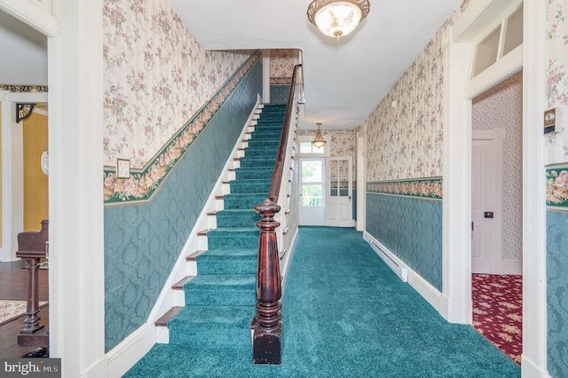 interior space with carpet, a baseboard radiator, wainscoting, baseboards, and wallpapered walls