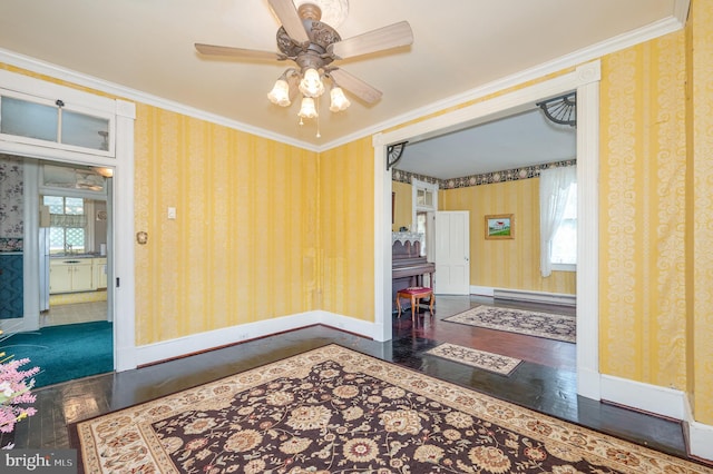 interior space featuring ornamental molding, dark wood-type flooring, baseboard heating, and ceiling fan