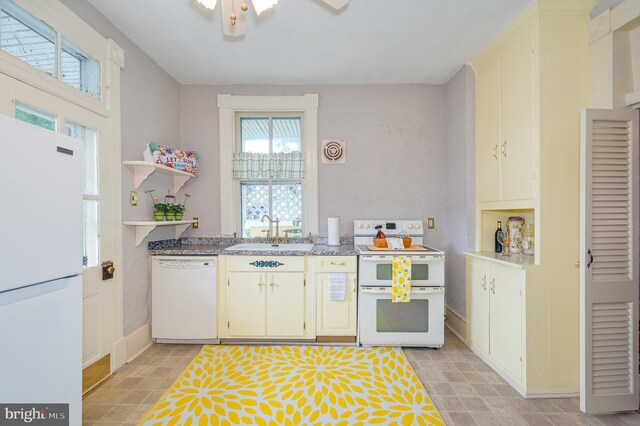 kitchen featuring white appliances, light tile patterned floors, and sink