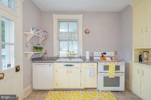 kitchen featuring a healthy amount of sunlight, sink, white appliances, and light tile patterned flooring