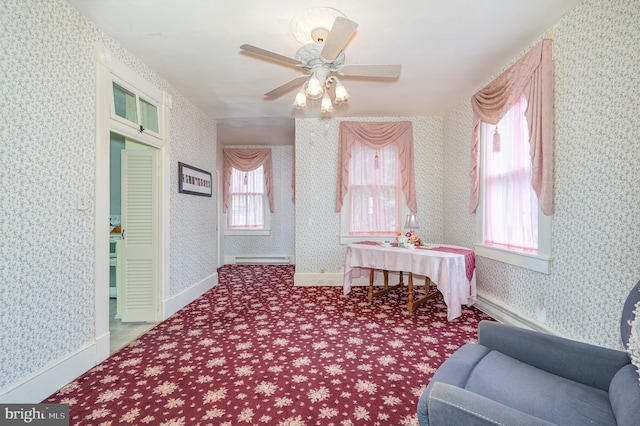 living area featuring a baseboard heating unit and ceiling fan