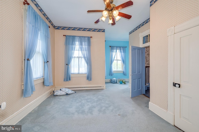 carpeted bedroom with a baseboard heating unit and ceiling fan