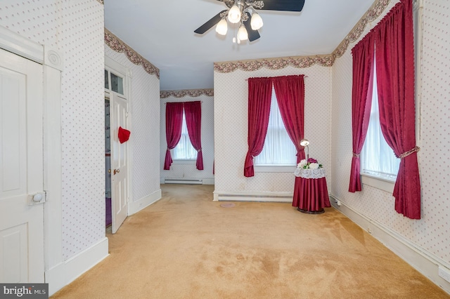 interior space featuring carpet floors, multiple windows, baseboards, and wallpapered walls