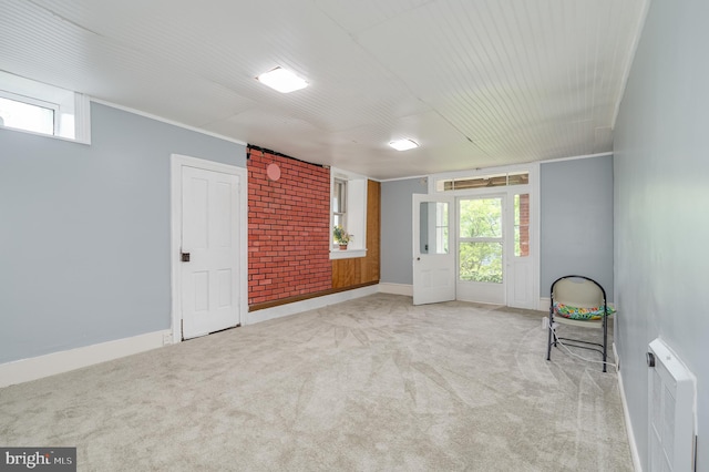 spare room with baseboards, ornamental molding, and light colored carpet