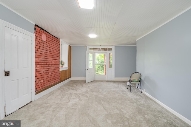 unfurnished room featuring brick wall and light colored carpet