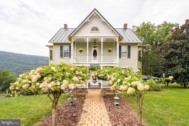 victorian-style house with a front yard and covered porch