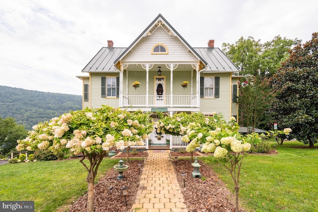 victorian home with a standing seam roof, a chimney, and metal roof