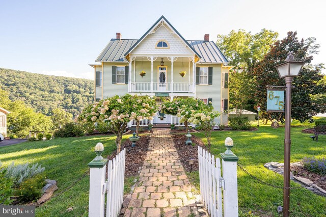 victorian house with a porch and a front lawn