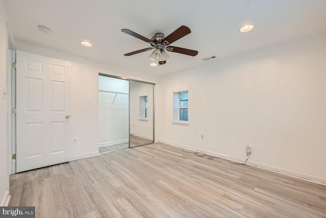 unfurnished bedroom featuring ceiling fan, a closet, and light hardwood / wood-style flooring