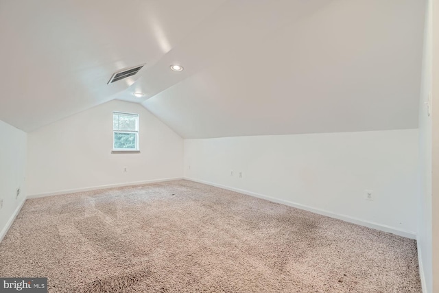 bonus room featuring vaulted ceiling and carpet