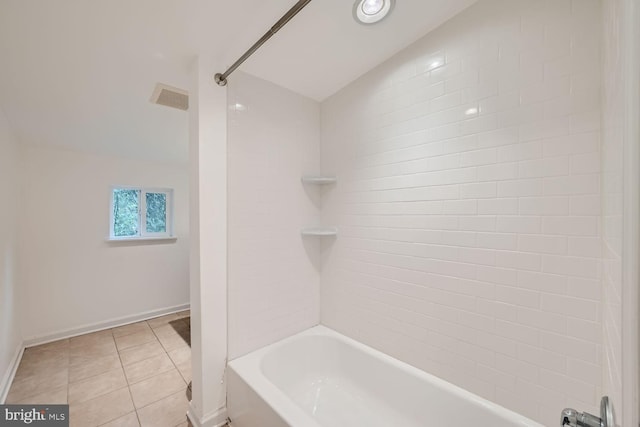 bathroom featuring vaulted ceiling, tile patterned floors, and tiled shower / bath