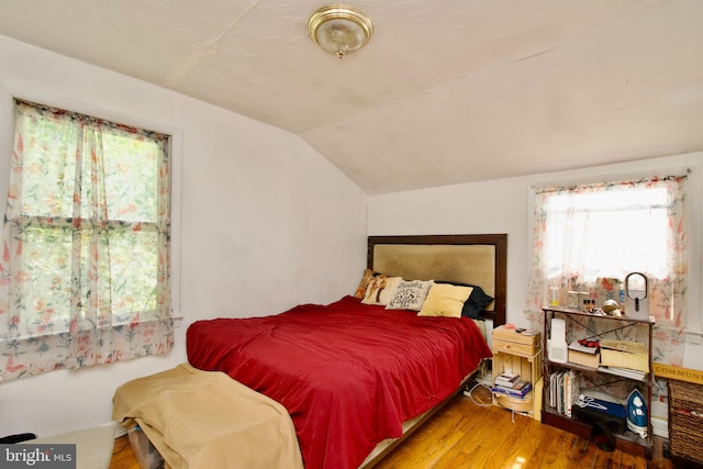 bedroom featuring vaulted ceiling and wood-type flooring