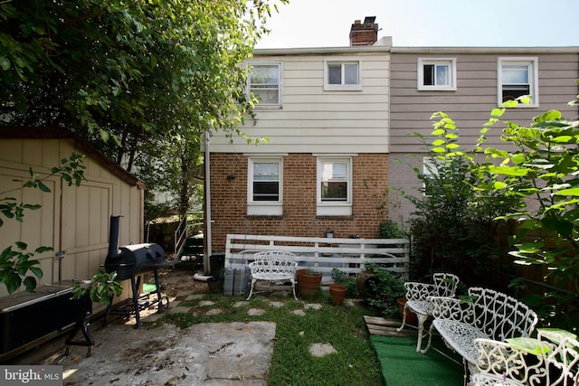 rear view of house with a storage shed