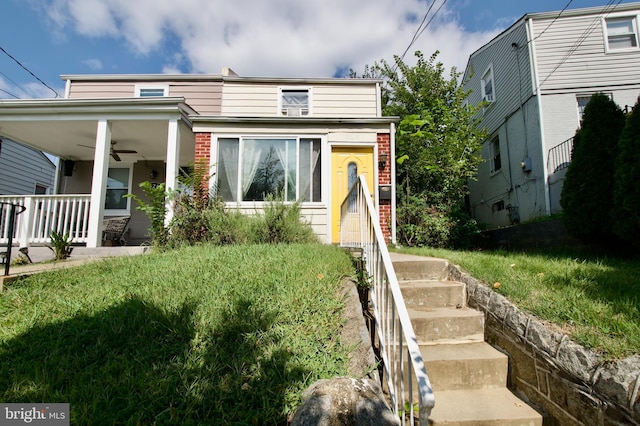 view of front of house with a front lawn and ceiling fan